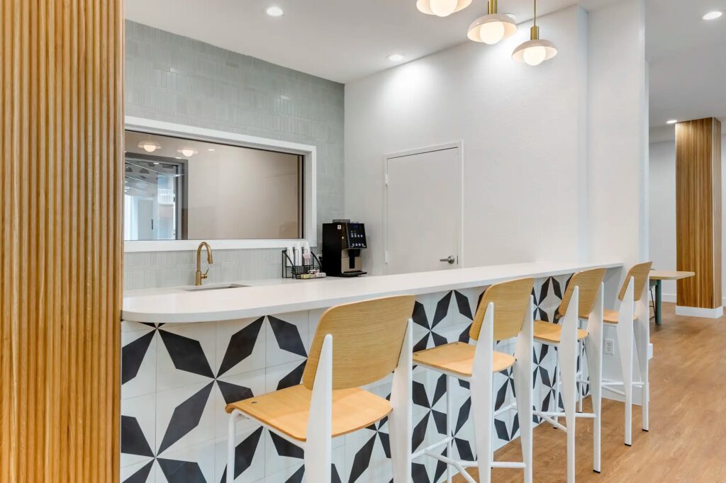clubhouse kitchen area with coffee maker, sink, and barstool seating