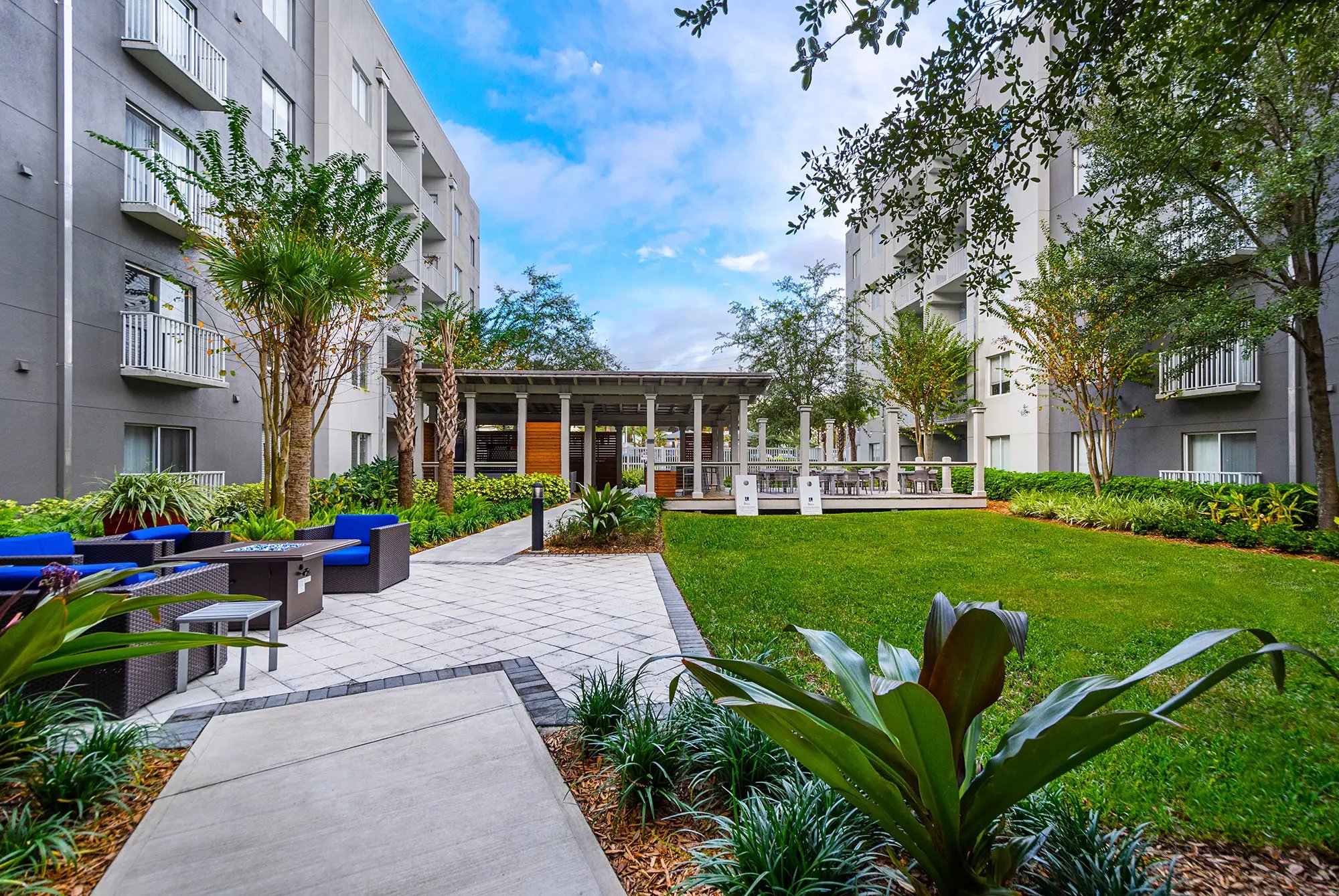 Courtyard with open sitting area and covered sitting area with tables and chairs.