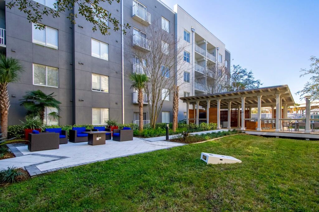 Outdoor seating area with corn hole board and covered out door kitchen area