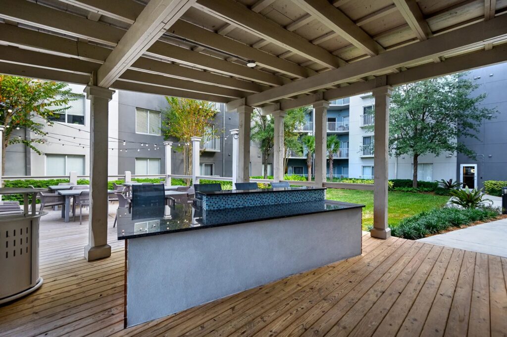 Outdoor covered patio with bar, tables, and chairs.