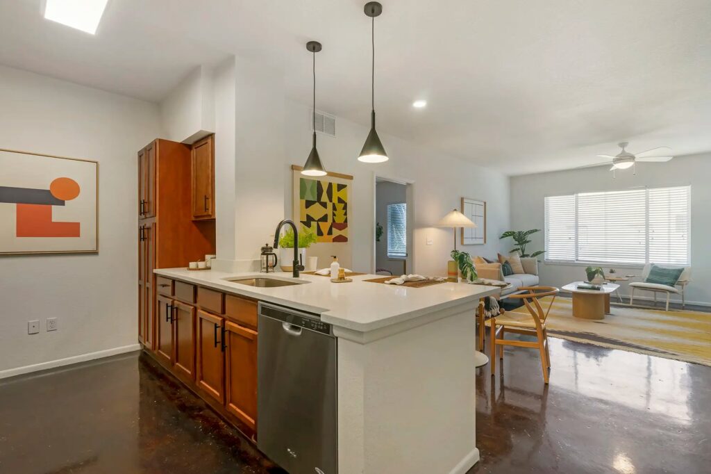Kitchen with double sink and dishwasher with view of dining and living room